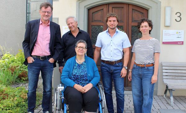 frühförderstelle markdorf das bild zeigt eine gruppe von mitarbeitenden der frühförderstelle. eine frau sitzt im rollstuhl.