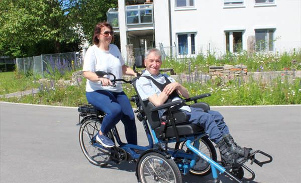 Rollstuhlfahrrad Das Foto zeigt Anja Rundel, Einrichtungsleitung Haus St. Raphael, und Karl Schlenska auf dem Rollstuhlfahrrad.
