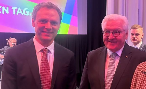 Bundespräsident Zwei Männer im Anzug stehen nebeneinander und schauen in die Kamera.