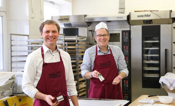 Das Foto zeigt Christian Braun und Dr. Thorsten Denkmann beim Backen.