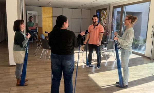 Übungen am Gesundheitstag Vier Personen trainieren mit Bändern.