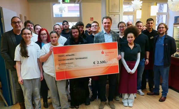 Aktion Spenden für Partnerschule Eine Gruppe Schülerinnen und Schüler hält einen Spendenscheck.
