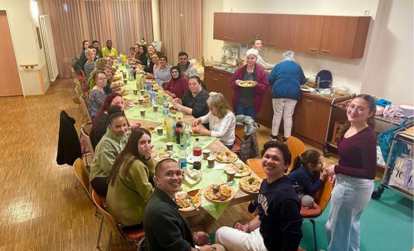 Fastenbrechen Eine Gruppe sitzt am Tisch und lächelt in die Kamera