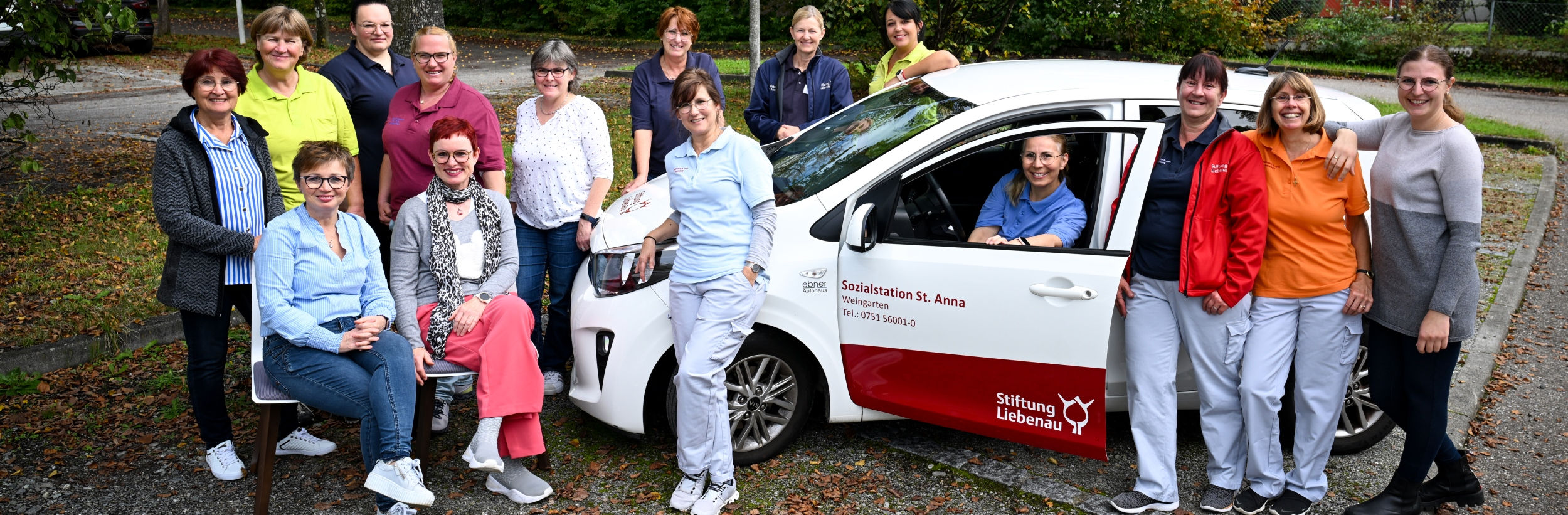 Das Bild zeigt die Mitarbeitenden der Sozialstaion Weingarten vor einem Auto