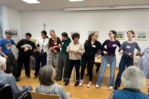 Gruppe Das Bild zeigt eine Gruppe von Personen die alle aneinander gereiht sind und Tanzen