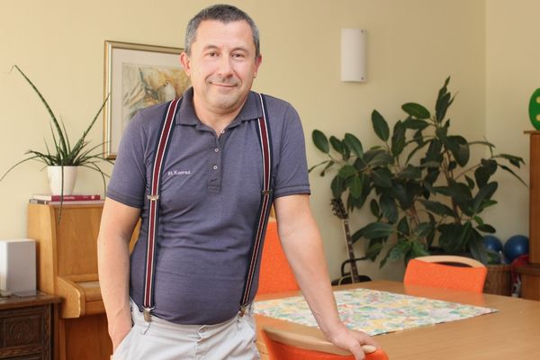 Frank Winkler Das Bild zeigt einen Mann in Hosenträgern der an einem Tisch lehnt und in die Kamera lächelt