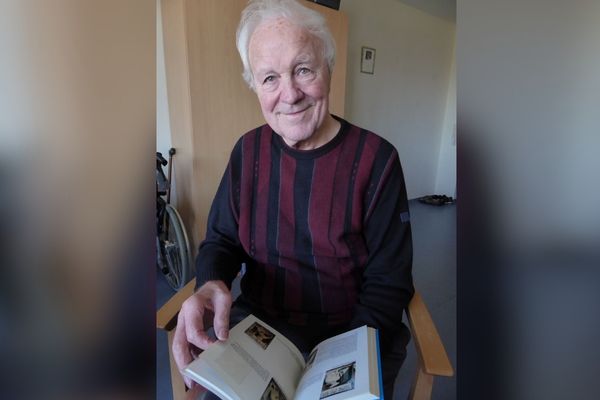 Herbert Mayer Das Bild zeigt einen Mann mit grauen Haaren und einem gestreiften Pullover, der gerade ein Buch liest