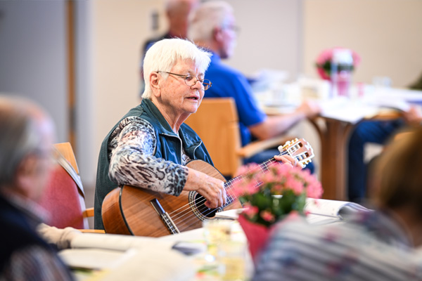 Betreuungsangebote Eine Frau spielt Gitarre beim Betreuungsangebot im Haus der Pflege St. Gebhard