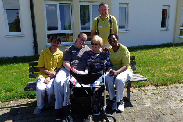 Infotag Pflege Das Foto zeigt einige Mitarbeiterinnen und Mitarbeiter und eine Bewohnerin.