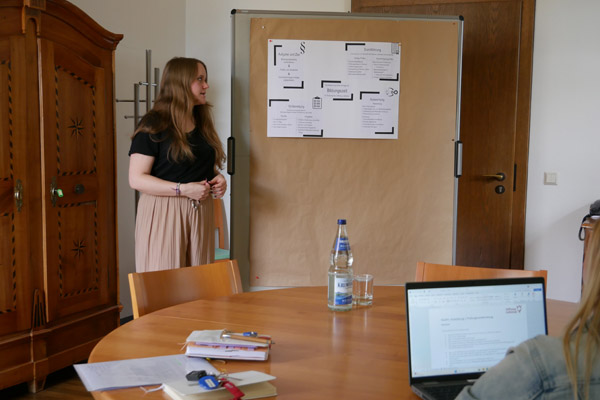 Prüfungsvorbereitung Eine Schülerin präsentiert etwas auf einem Plakat.