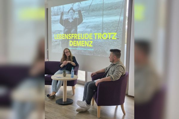 Einrichtungsleiterin Carolyn Thomas und Pflegeblogger Sandro Pé Zwei Menschen sitzen und unterhalten sich