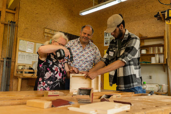 BBW Open Drei Personen bauen zusammen etwas aus Holz.