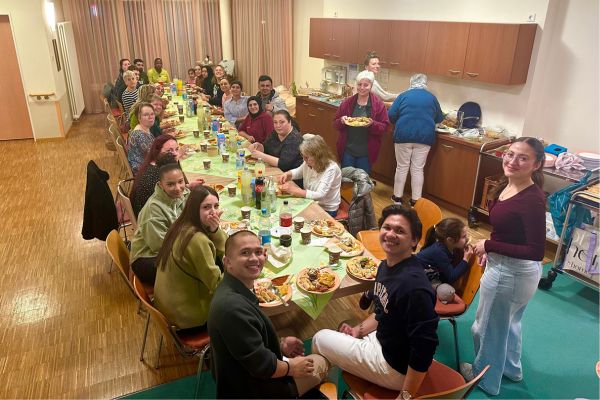 Fastenbrechen Eine Gruppe sitzt am Tisch und lächelt in die Kamera