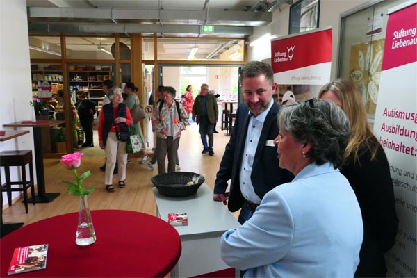 Tag der offenen Tür Ein Messestand mit mehreren Personen in einem Foyer.