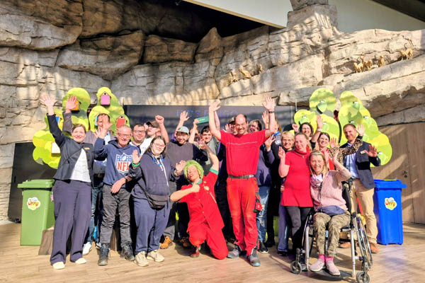 Viele Personen bei einem Gruppenbild strecken die Hände in die Luft.