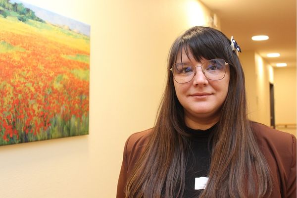 Zhana Alfers Eine braunhaarige Frau schaut in die Kamera und lächelt.