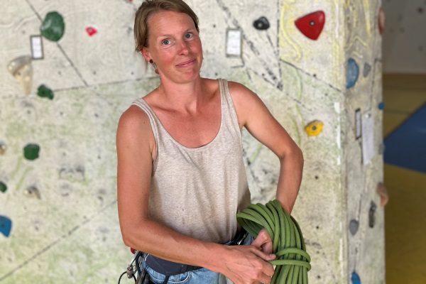 Das Bild zeigt die Heilpädagogin Andrea Sprenger vor der Kletterwand