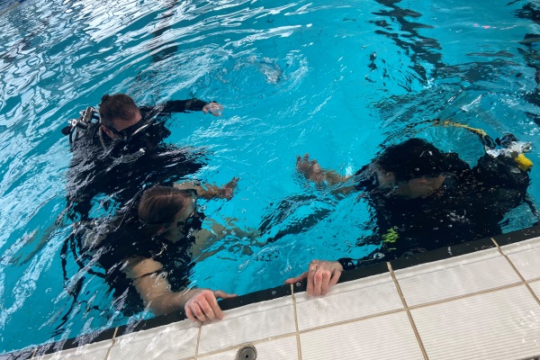 Das Bild zeigt zwei Taucher im Wasser kurz vor dem Tauchgang