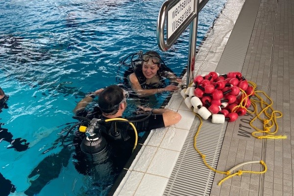 Das Bild zeigt Annika Bader mit ihrem Trainer nach dem Tauchgang am Beckenrand