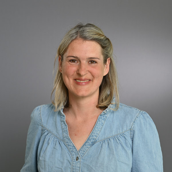 Portraitfoto Eine Frau lächelt in die Kamera für ein Portraitfoto.
