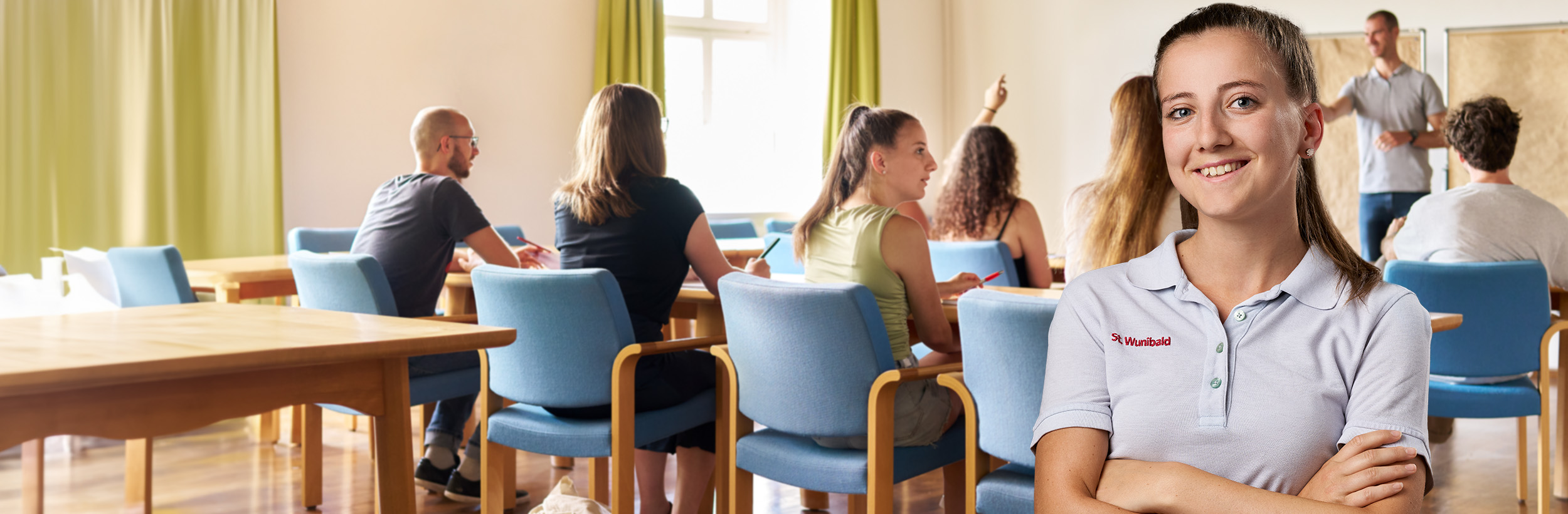 Das Bild zeigt ein Portrait einer Mitarbeiterin der Pflege im Vordergrund. Im Hintergrund ist die Mitarbeiterin in einem Schulungsraum zu sehen.