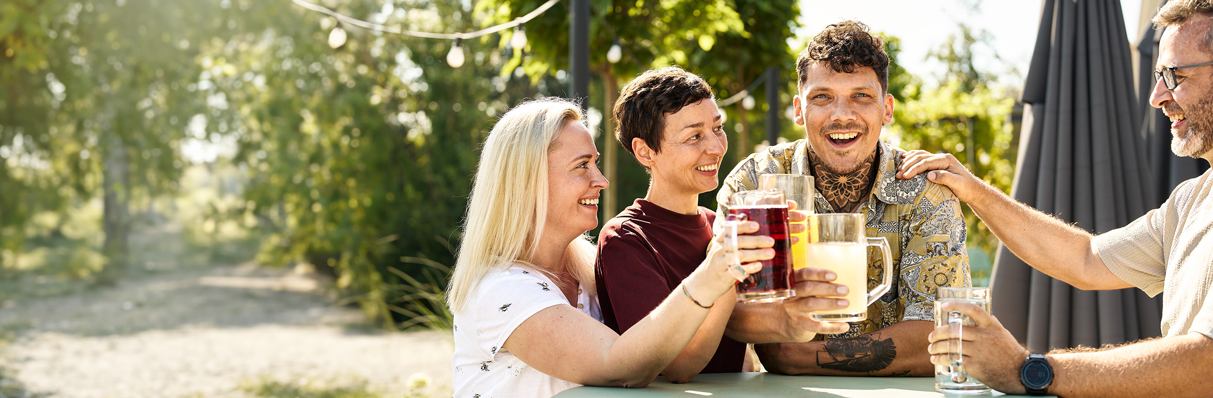 Vier Personen mit Getränk in der Hand.